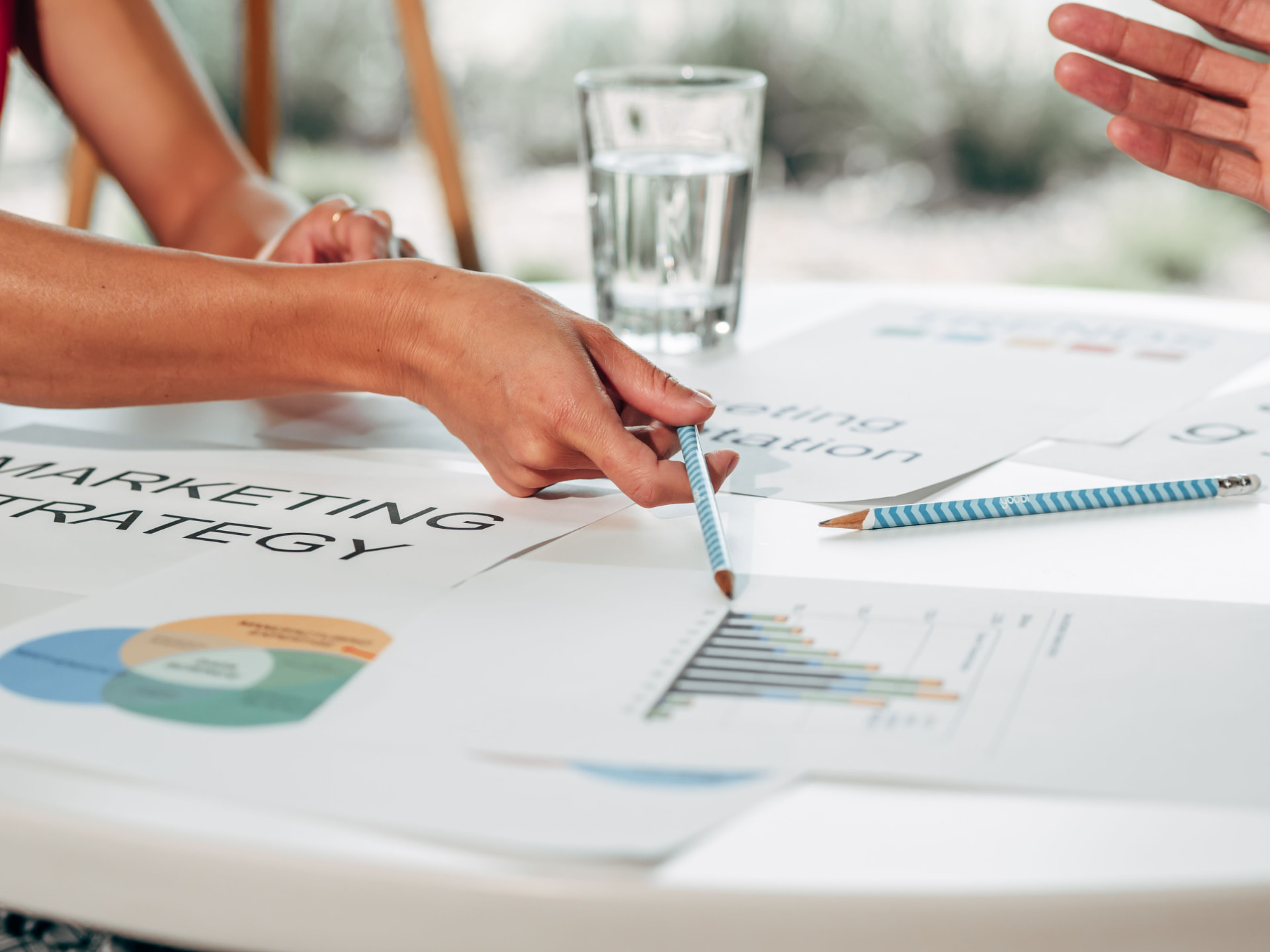 Two people reviewing a marketing strategy document and performance charts