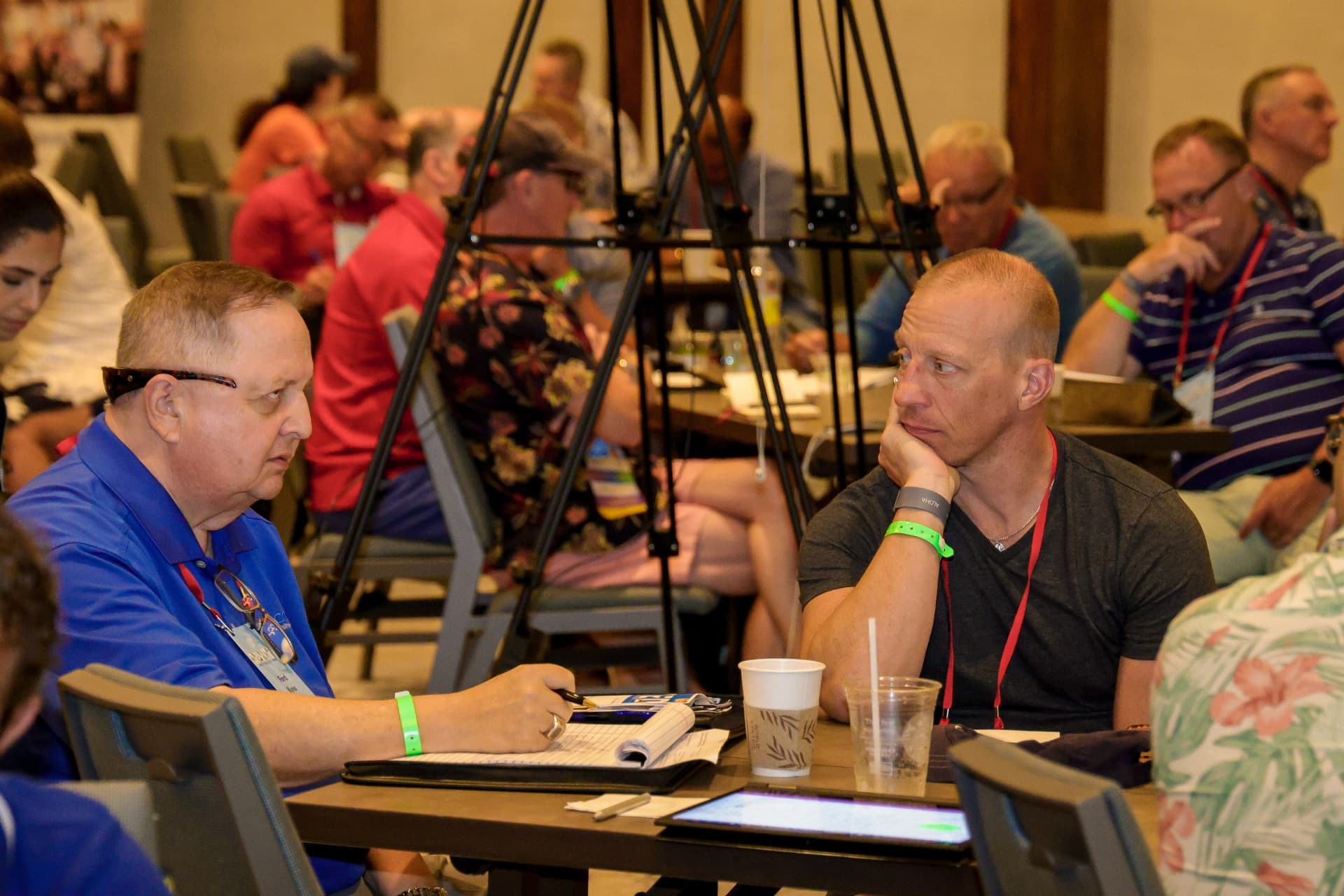 Two workshop attendees discussing notes at a table during an AI training session